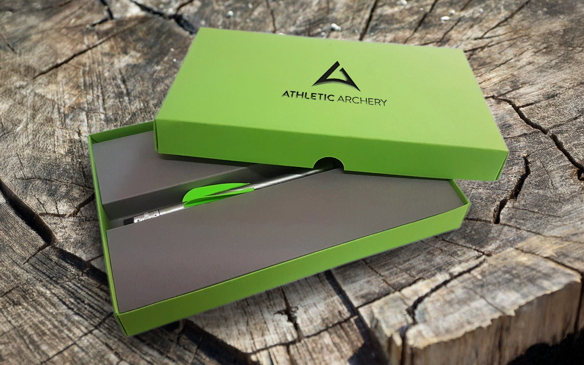 Product shot of the mailing for athletic archery with designed packaging and a custom-made pen, refined with fletching typical of archery. Design by R211 agency.