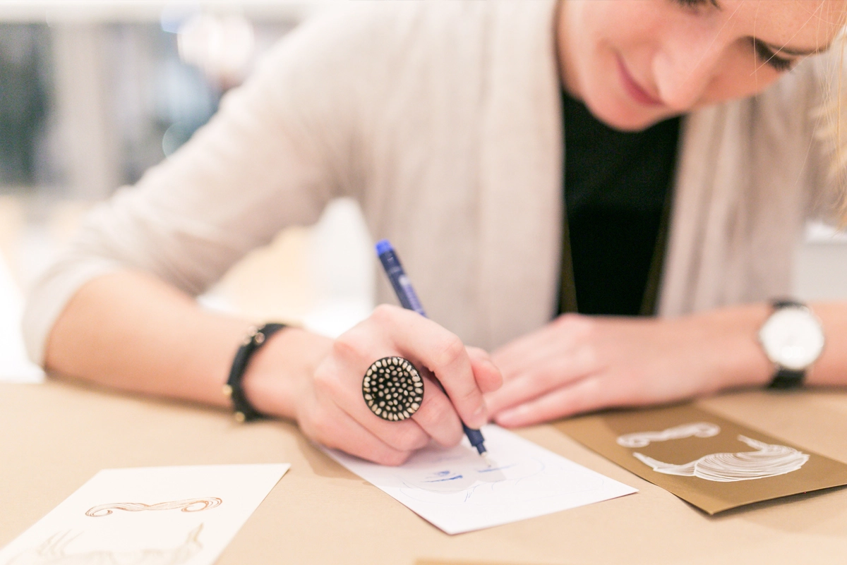 Close-up of an event visitor testing the presented paper and writing on it. Image from the Paper Playground Event by Freytag & Petersen, visually designed by the R211 agency.