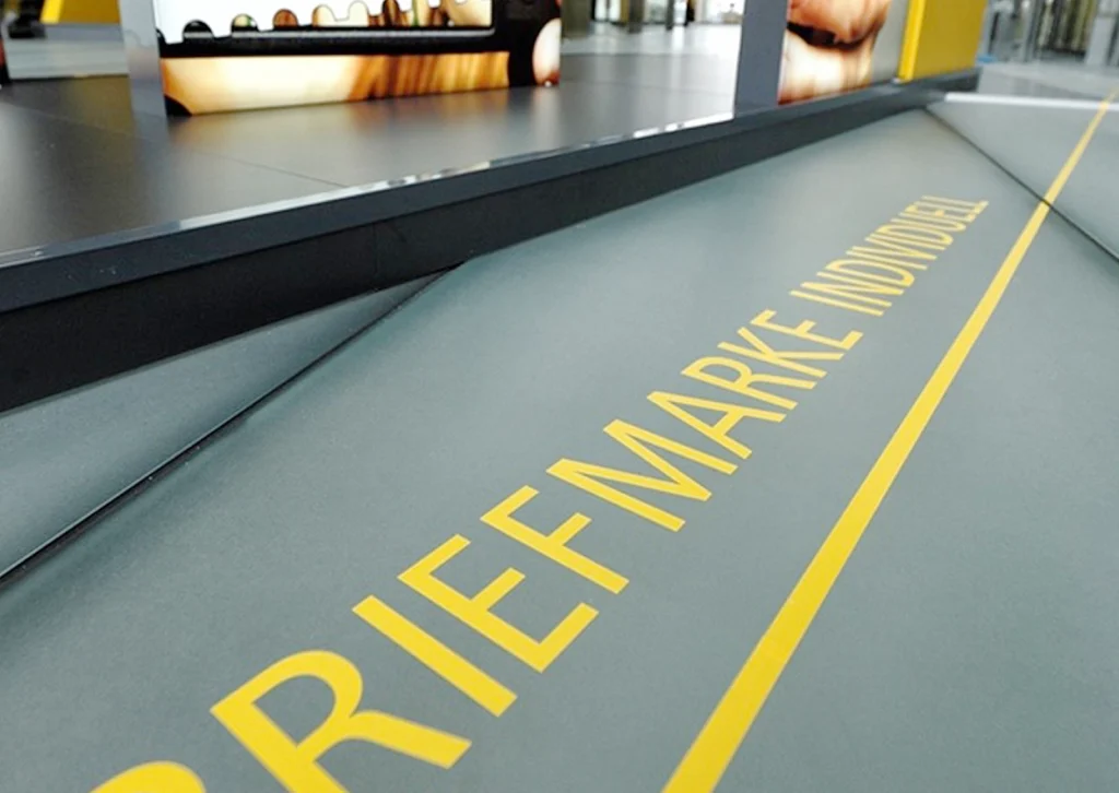 Ansicht einer Bodengrafik der Medien-Station zum Thema "Briefmarke Individuell" der Ausstellung Level 3.0 im Deutsche Post DHL Tower in Bonn